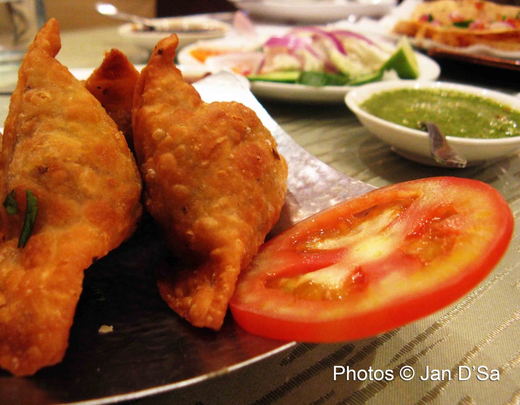 The unforgettable samosas, with the assorted relishes in the background.