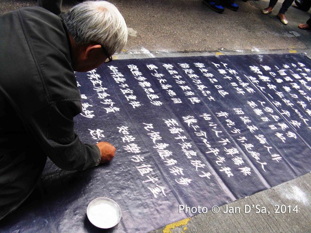 Caught this old man writing in the Chinese alphabet with chalk powder and fingers. Meticulous work!
